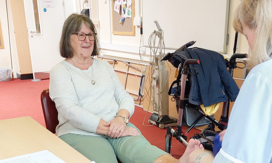 Lady having a foot treatment by another lady at a community centre