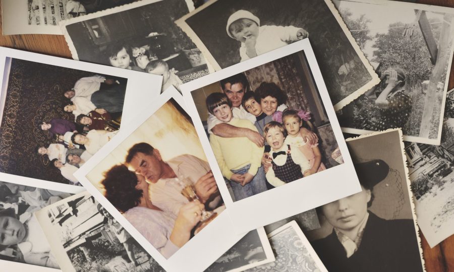 Pile of family photographs on table, overhead view